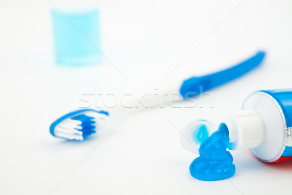 Close up of a toothbrush next to a tube of toothpaste against white background Stock photo © wavebreak_media