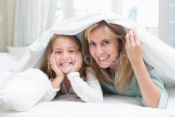 Mother and daughter looking at camera under the duvet  Stock photo © wavebreak_media
