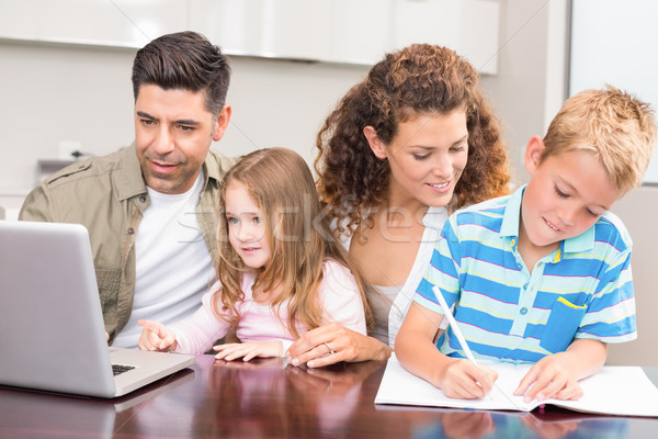 Cheerful parents colouring and using laptop with their children Stock photo © wavebreak_media
