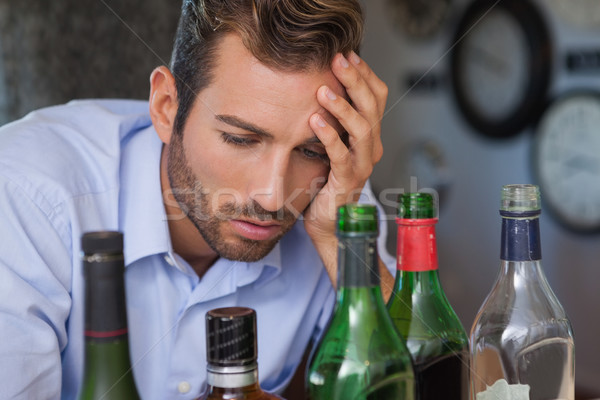 Drunk businessman looking at spirit bottles Stock photo © wavebreak_media