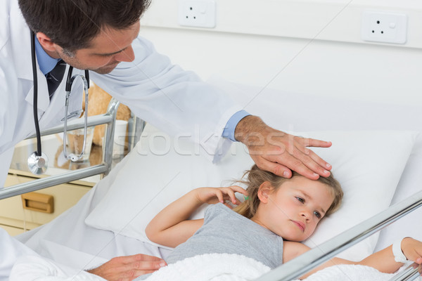 Doctor checking temperature of sick girl Stock photo © wavebreak_media