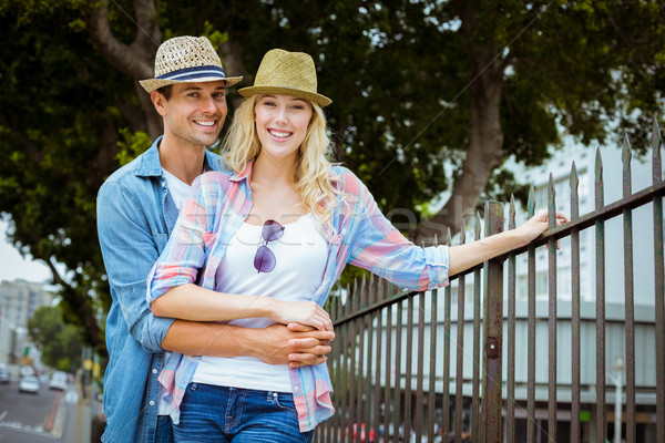Hip young couple smiling at camera by railings Stock photo © wavebreak_media