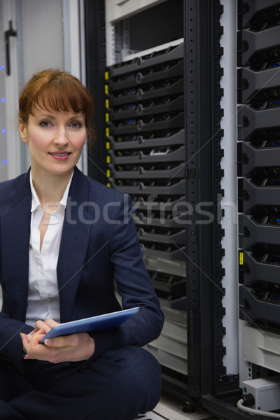 Happy technician sitting on floor beside server tower using tabl Stock photo © wavebreak_media