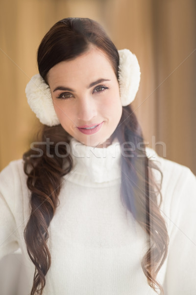 Pretty brunette with ear muffs smiling at camera Stock photo © wavebreak_media
