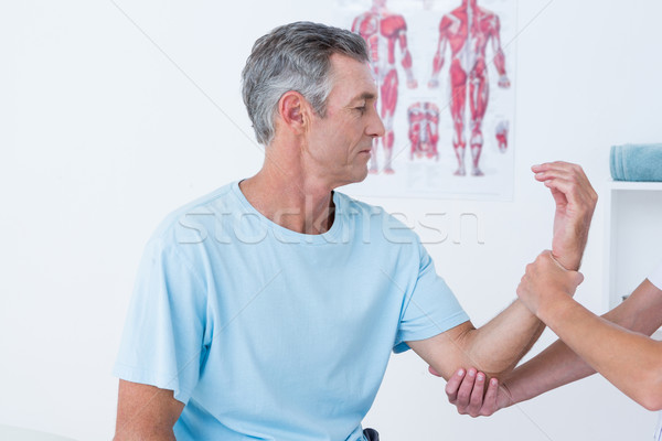 Stock photo: Doctor examining her patient arm