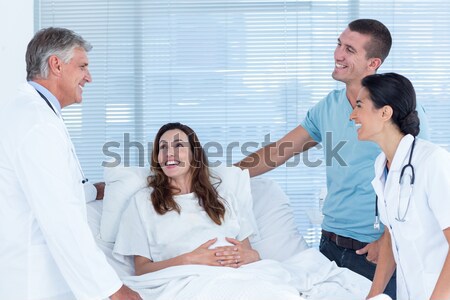 Stock photo: Future parents talking with smiling doctors