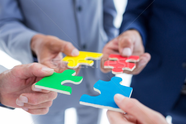 Stock photo: Business colleagues holding piece of puzzle