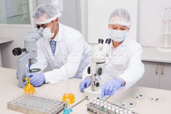 Scientists examining tubes with microscope Stock photo © wavebreak_media