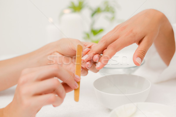 Stock photo: Beautician filing female clients nails at spa beauty salon