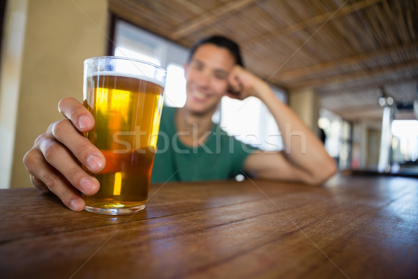 Man holding beer glass at bar counter Stock photo © wavebreak_media