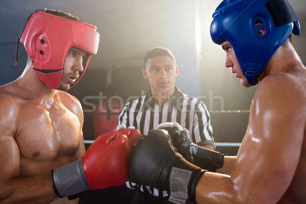 Referee looking at male boxers punching gloves Stock photo © wavebreak_media