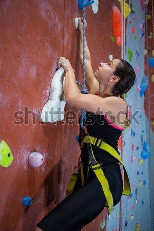 Stock photo: Determined teenage girl practicing rock climbing