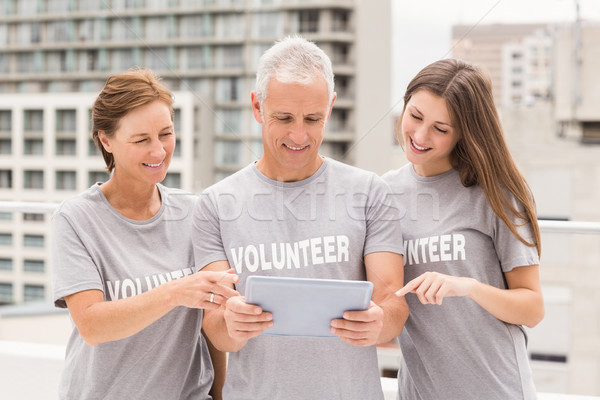 Smiling volunteers using tablet together Stock photo © wavebreak_media