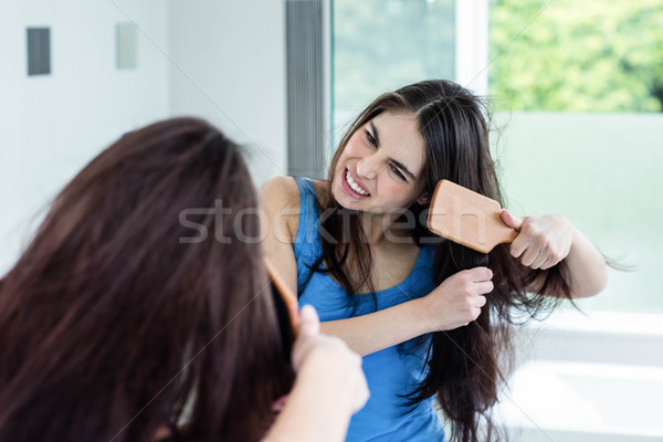 Stock photo: Unsmiling brunette combing