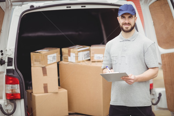 Delivery man writing on clipboard Stock photo © wavebreak_media