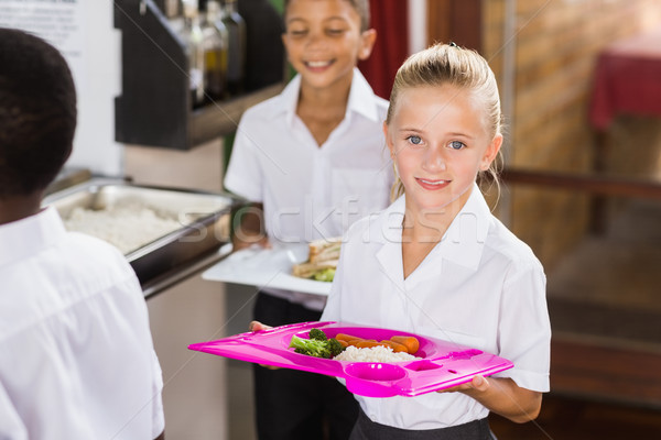 Souriant écolière alimentaire plateau école [[stock_photo]] © wavebreak_media