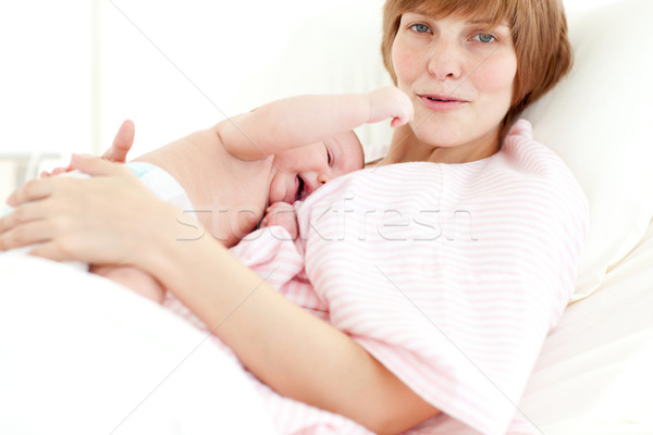Stock photo: Mother embracing her newborn baby