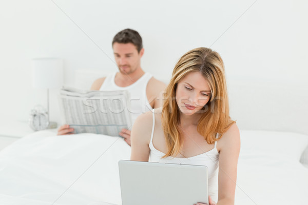 Frau Laptop Ehemann Lesung Zeitung Bett Stock foto © wavebreak_media
