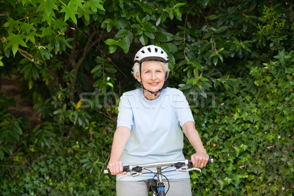 Stock photo: Mature woman mountain biking outside