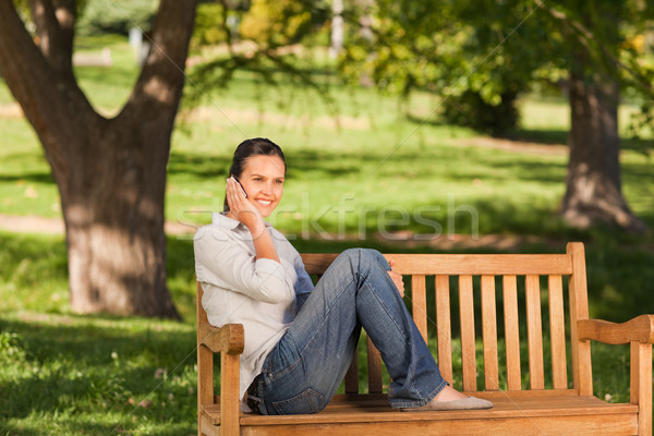 Young beautiful woman phoning on the bench Stock photo © wavebreak_media