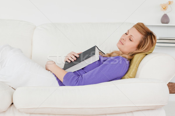 Pretty woman lying on the sofa who has fallen asleep while reading a book  Stock photo © wavebreak_media