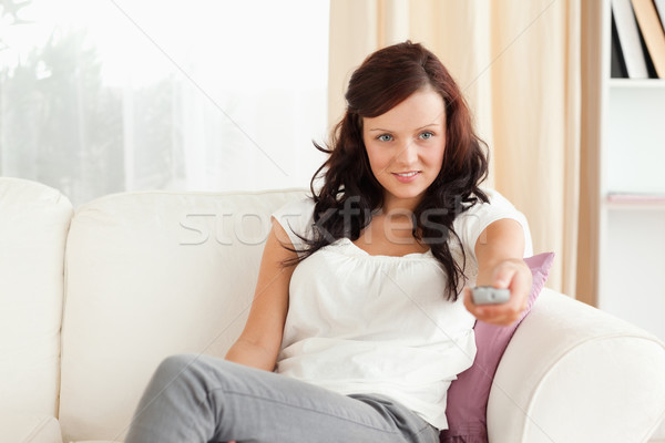 Young woman watching TV in her livingroom Stock photo © wavebreak_media