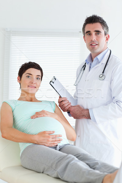 Doctor and pregnant patient looking at the camera in a room Stock photo © wavebreak_media