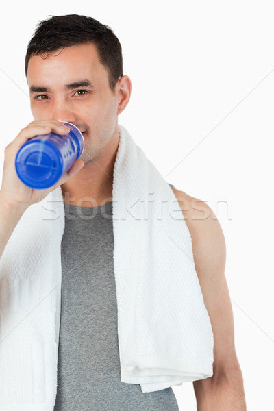 Young man taking a sip of water after training against a white background Stock photo © wavebreak_media