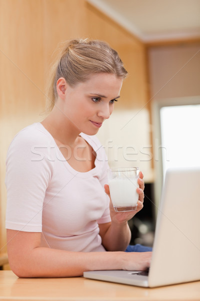 Stockfoto: Portret · vrouw · met · behulp · van · laptop · drinken · melk · keuken