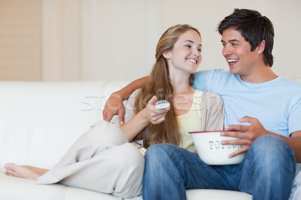 Charming couple watching television while eating popcorn in their living room Stock photo © wavebreak_media