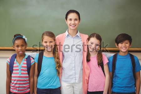 Schoolteacher posing with her pupils in a classroom Stock photo © wavebreak_media