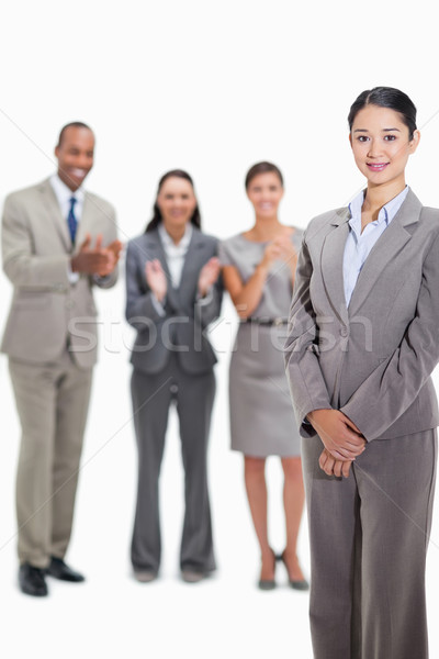Close-up of a businesswoman smiling with co-workers applauding and looking at her in the background Stock photo © wavebreak_media