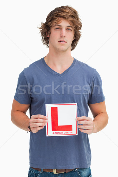 Young man holding a learner driver sign against white background Stock photo © wavebreak_media