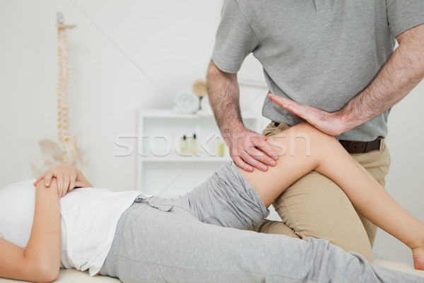 Serious osteopath massaging the knee of a patient in a room Stock photo © wavebreak_media