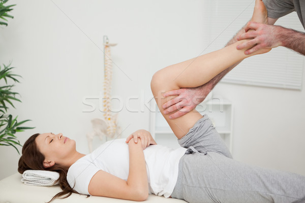 Stock photo: Serious brunette woman lying on a medical table in a room