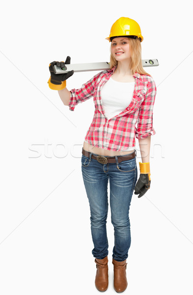 Joyful woman holding a spirit level against white background Stock photo © wavebreak_media