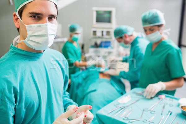 Surgeon wearing bloody gloves while looking at camera in an operating theatre Stock photo © wavebreak_media