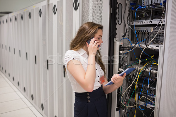 Woman on the phone holding tablet pc checking the servers in data center Stock photo © wavebreak_media