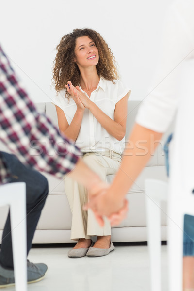 Stock photo: Pleased therapist looking at reconciled couple holding hands