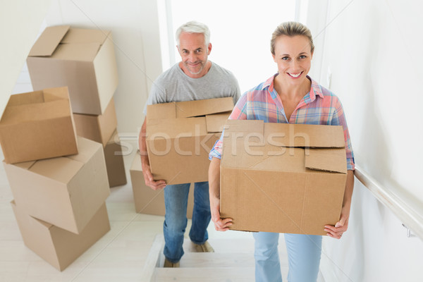 Happy couple carrying cardboard moving boxes  Stock photo © wavebreak_media