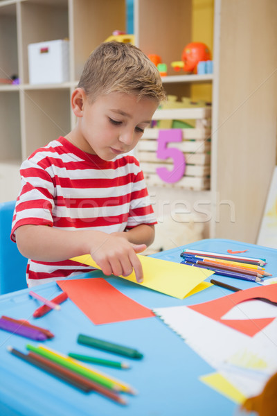 Cute little boy folding paper shapes in classroom Stock photo © wavebreak_media