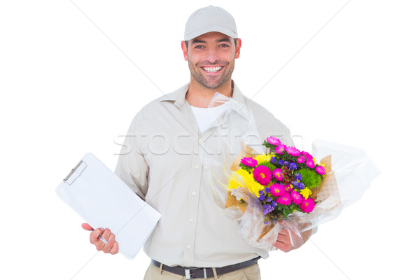 Happy flower delivery man holding clipboard Stock photo © wavebreak_media