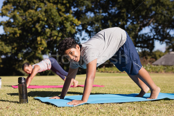 Stock photo: Portrait of happy boy practicing yoga with friend at park