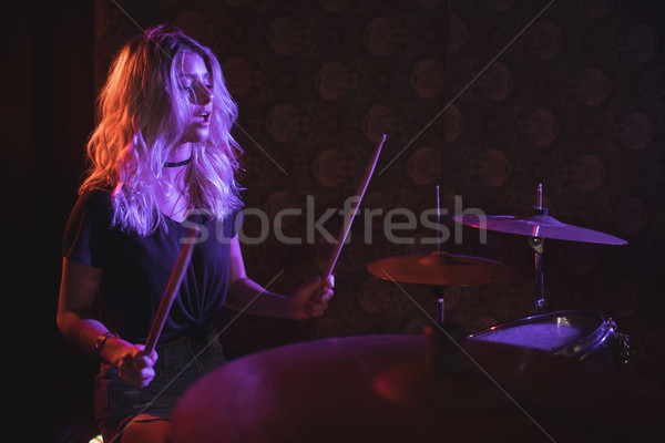 Confident female drummer performing on illuminated stage  Stock photo © wavebreak_media