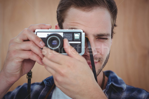 Handsome hipster taking picture with retro camera Stock photo © wavebreak_media