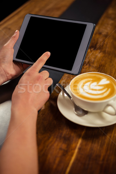 Woman drinking coffee and using tablet Stock photo © wavebreak_media