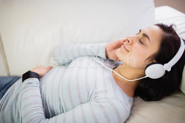 Vue femme écouter de la musique jeune femme maison [[stock_photo]] © wavebreak_media