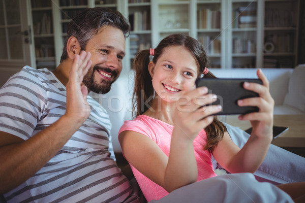 Foto stock: Sorridente · pai · filha · olhando · telefone · móvel · sala · de · estar