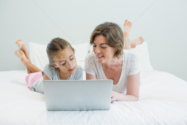 Smiling mother and daughter using laptop on bed Stock photo © wavebreak_media