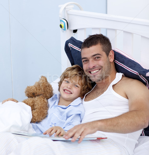 Smiling father and son reading a book in bed Stock photo © wavebreak_media